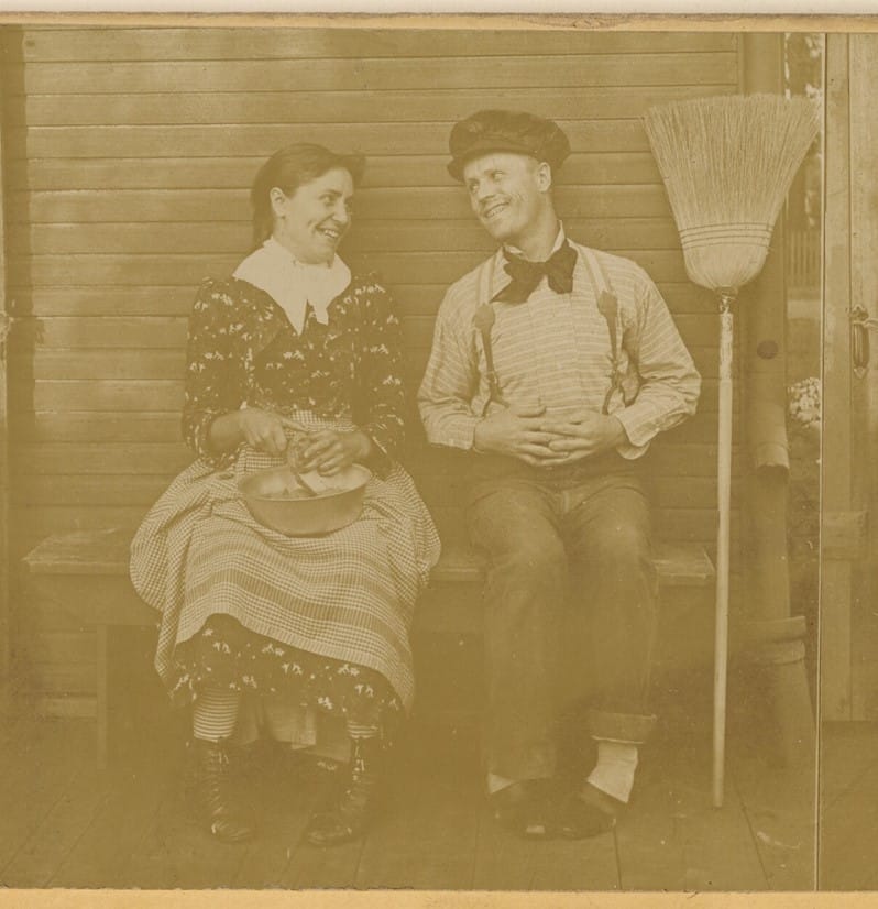 An 1892 photograph of a man and woman sitting on a bench, gazing and smiling at each other.