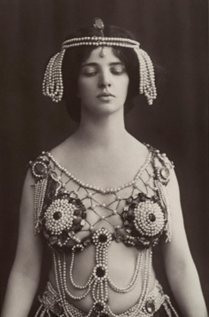 An old black & white photograph of a woman dressed in revealing ancient Roman garb.