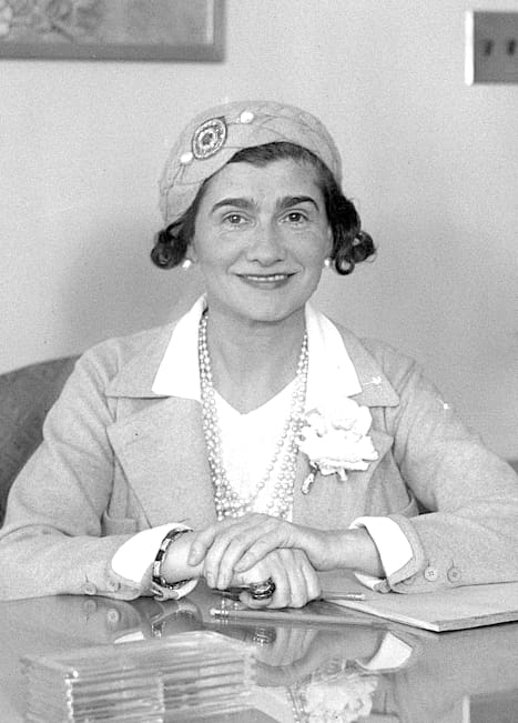 Photograph of a fashionable woman at her desk.