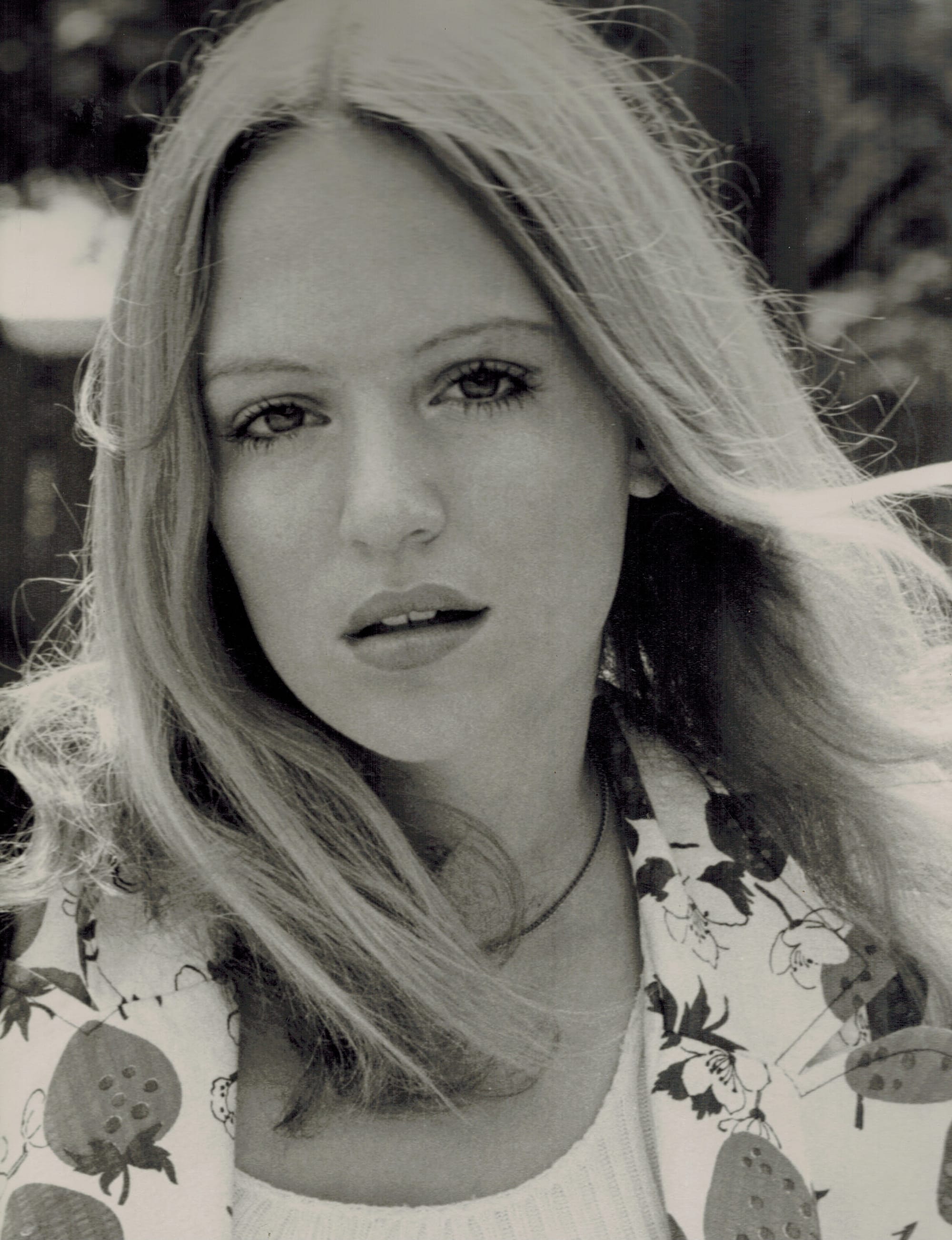 A headhshot photo of a pretty young blonde woman with wind-swept hair.