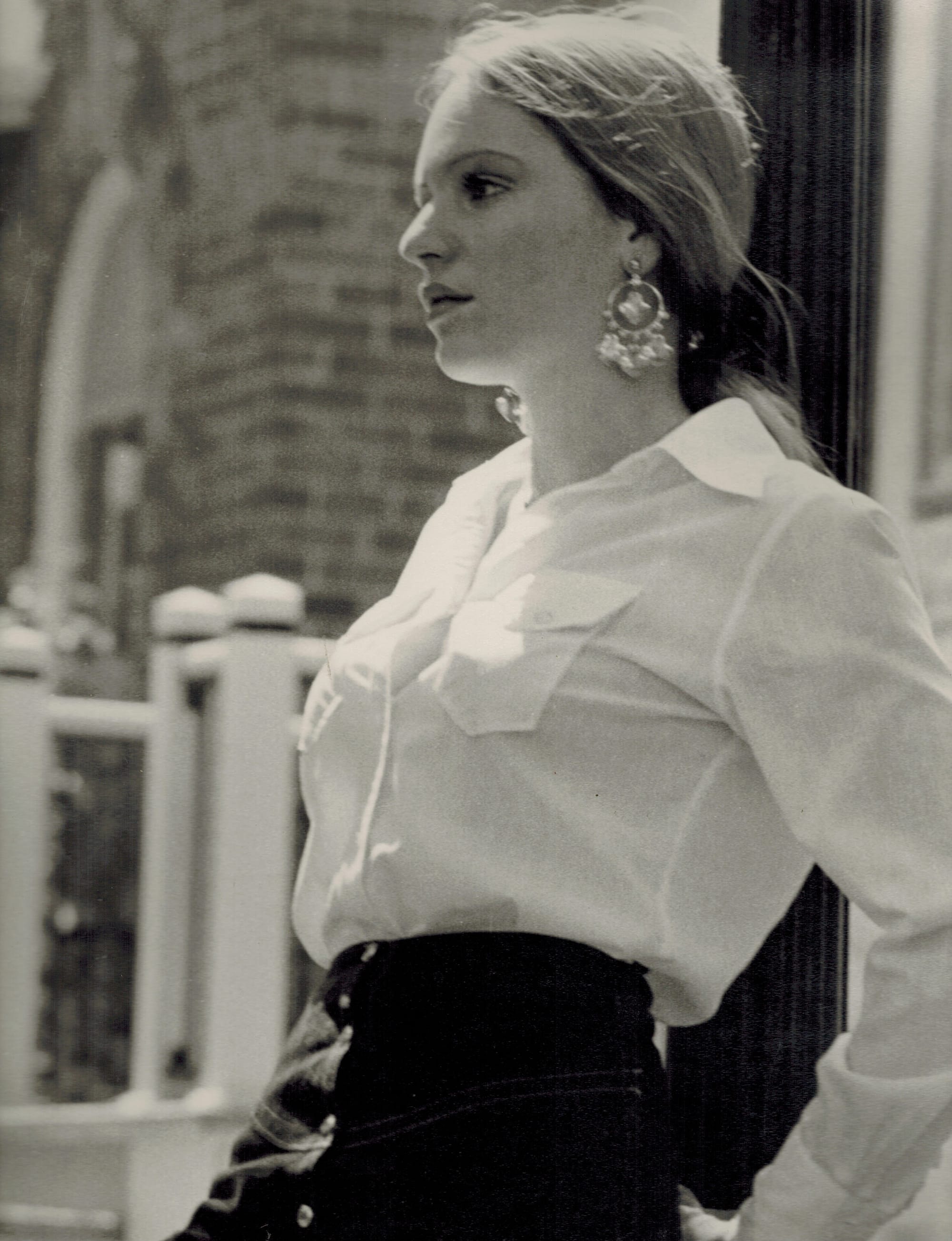 A pretty young woman poses for an oblique upper-body fashion shot.