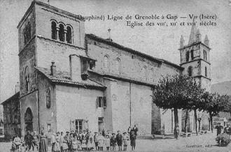 An old church with congregants standing in front.