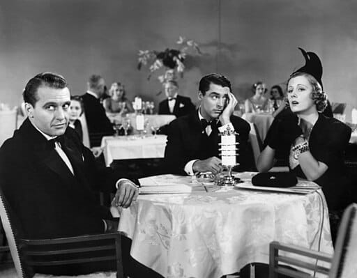 Still image from 1937 film featuring two men and a woman in formal atire at a dinner club.