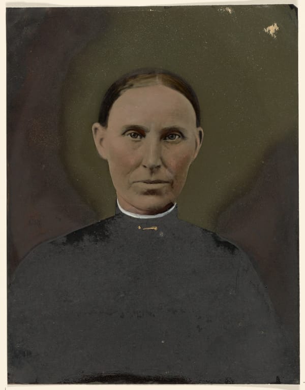 A colourized photogaphic portrait of a late 19th C. middle-aged woman dressed simply in dark clothing against a dark backg