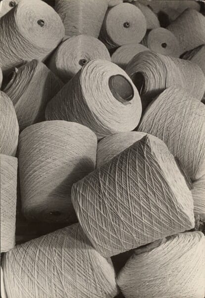 A photograph of spindles of thread all jumbled in a pile.