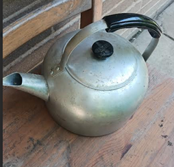 A photograph of a vintage aluminum kettle.