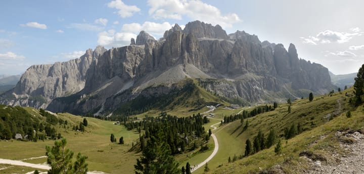 A photograph of a mountain with a green valley in the foreground.