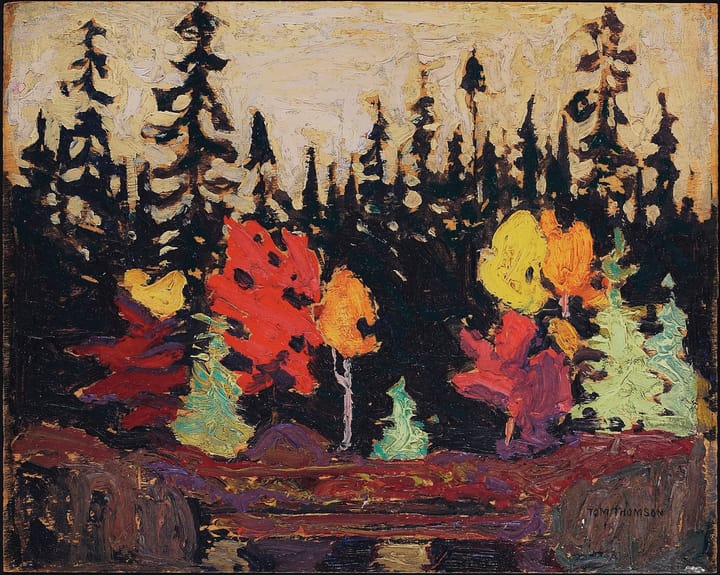 An impressionist painting of brightly hued deciduous trees on a rocky shoreline before a pine forest.